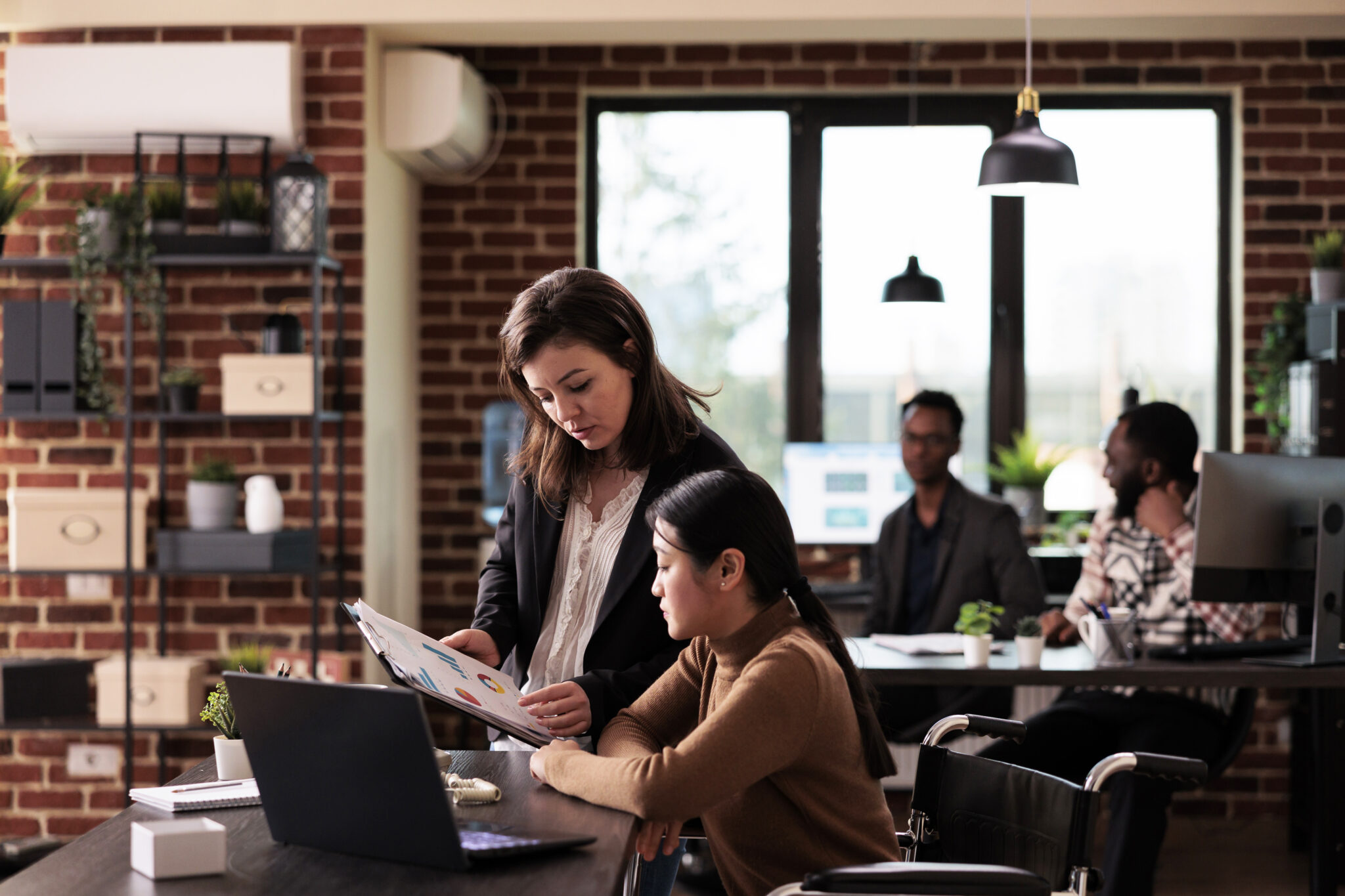 Diverse team of women analyzing documents report at job