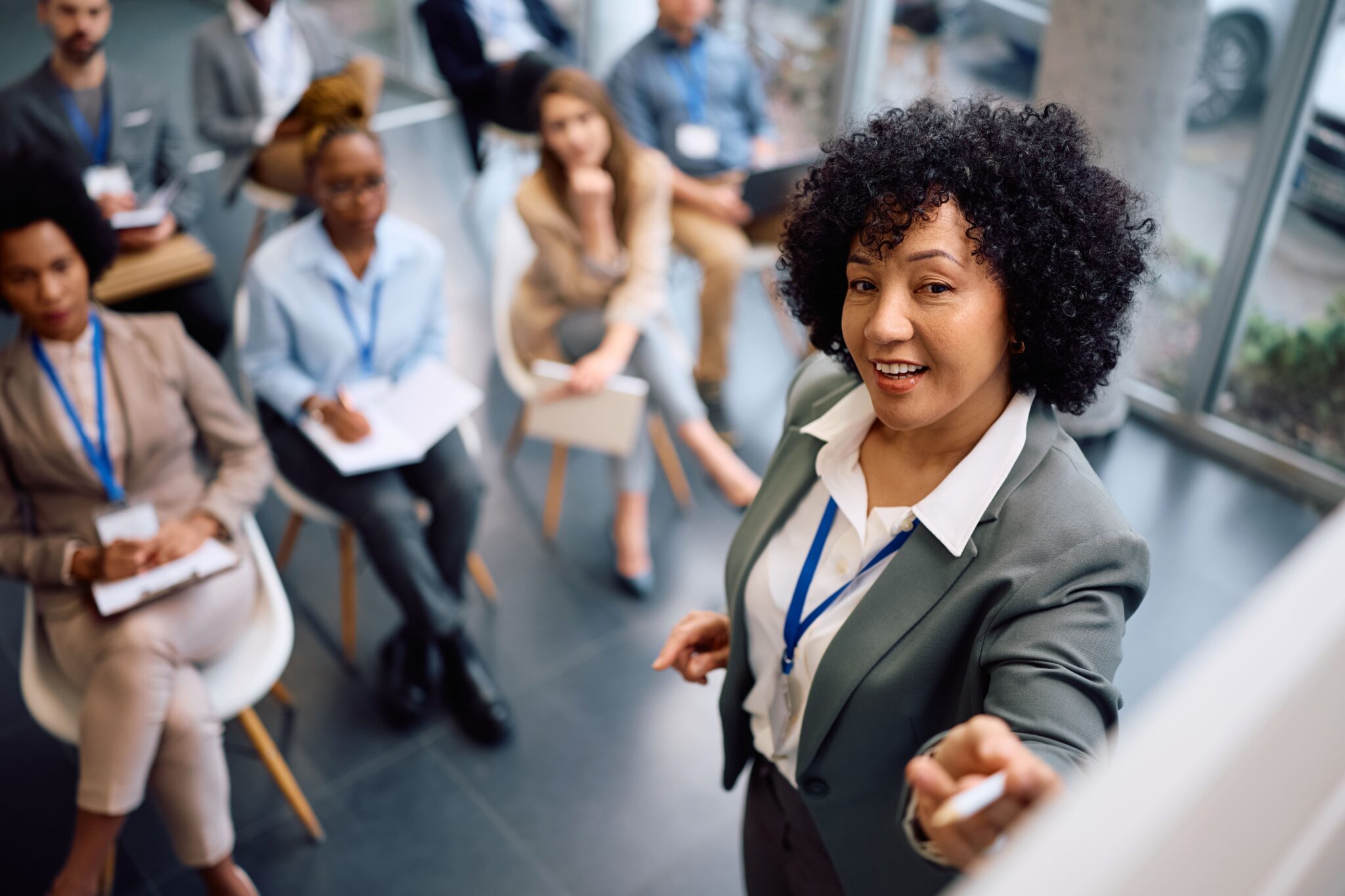 happy-mature-businesswoman-talking-to-group-of-sem-2026-01-08-22-47-31-utc (1)